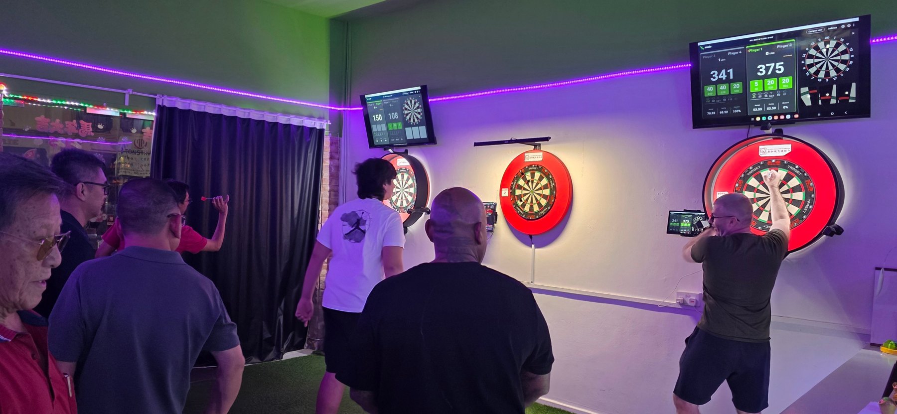Players taking their turns at the steel-tip boards